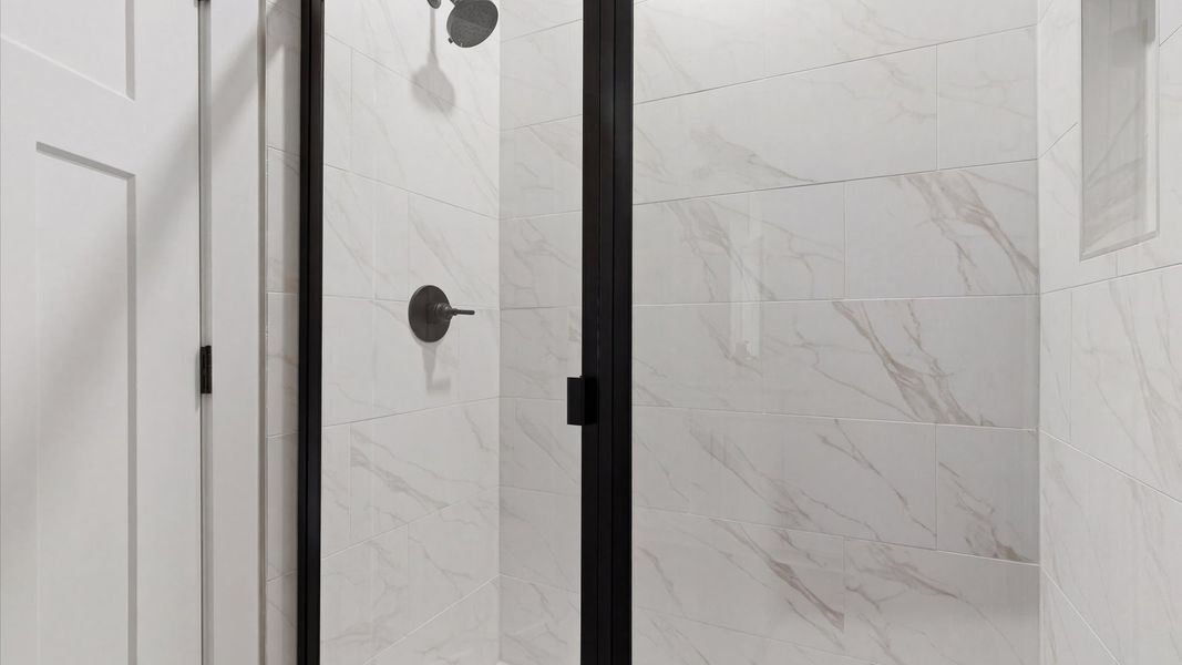 Memorable mornings begin in this elegant primary bathroom with walk-in shower and double vanity