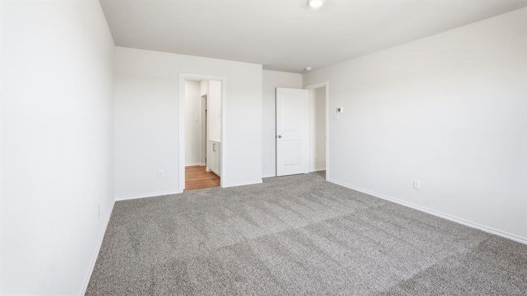 Unfurnished bedroom with light carpet and ensuite bath
