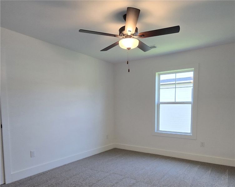 A well-lit 3rd bedroom features plush carpeting an