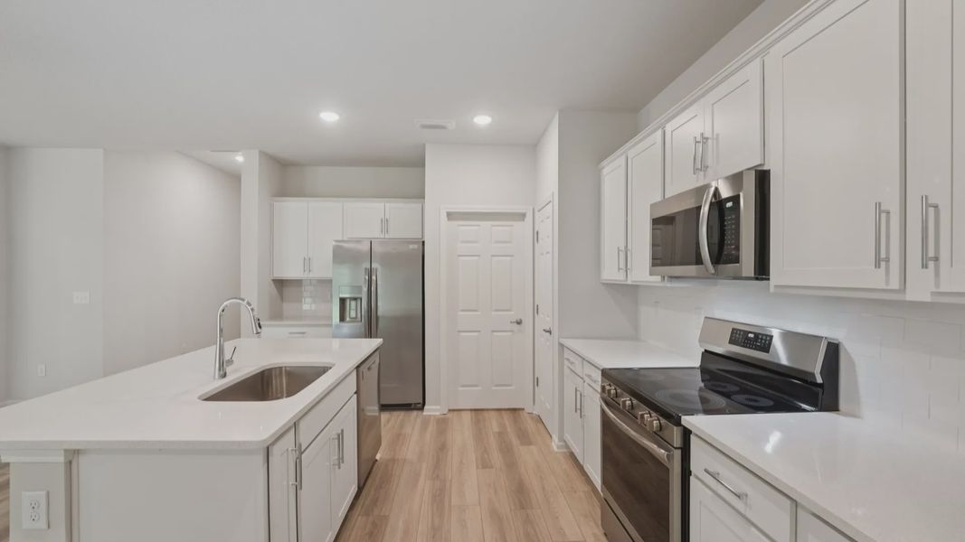 Sleek white cabinetry with quartz countertops and premium appliances make this Palm Coast kitchen truly exceptional.