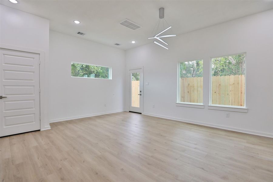 Bright and airy living room with abundant natural light. Back door leads to the fenced backyard.