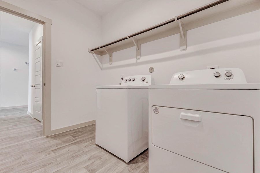 Conveniently located and move-in ready, this laundry room includes washer and dryer, overhead shelf for storage, and durable wood-look flooring. Bright, clean, and tucked just off the main hallway for easy access. Conveniently located and move-in ready, this laundry room includes washer and dryer, overhead shelf for storage, and durable wood-look flooring. Bright, clean, and tucked just off the main hallway for easy access.