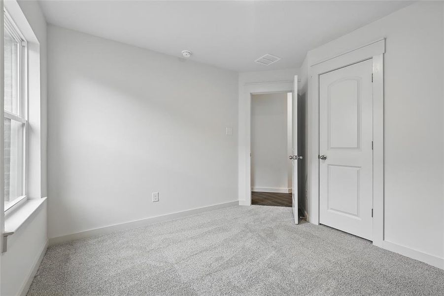 Unfurnished bedroom with light carpet and baseboards Unfurnished bedroom with light carpet and baseboards