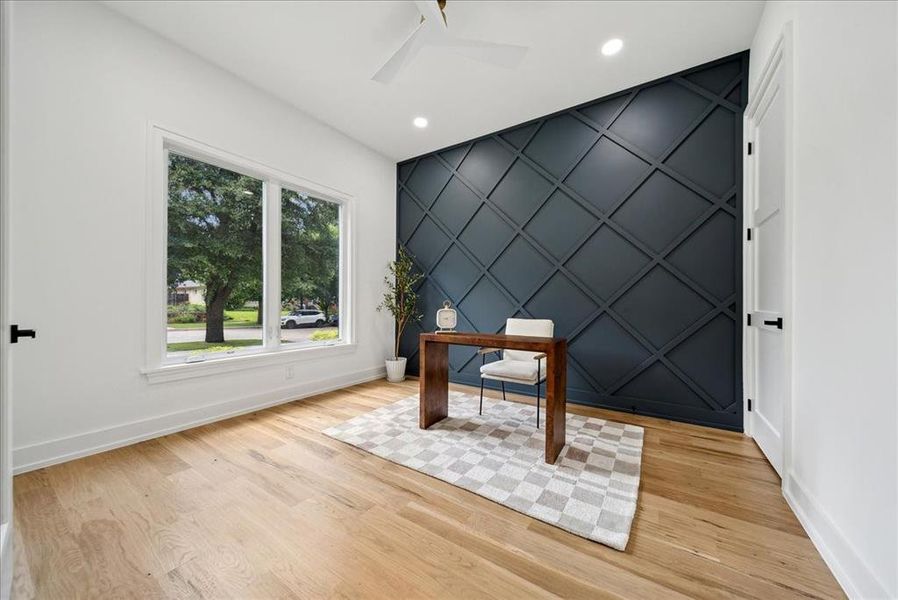 Office area with light hardwood floors and ceiling fan