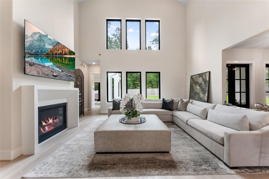 The main living room features soaring ceilings, expansive windows, and a custom entertainment wall. The room is designed for everyday gathering with surround sound enhancing the experience. With no neighbors behind, your living areas are extremely private.