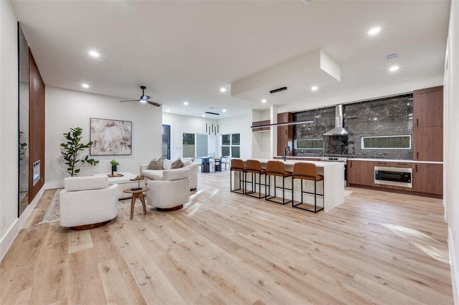 Living area featuring light wood-type flooring, ceiling fan, and recessed lighting