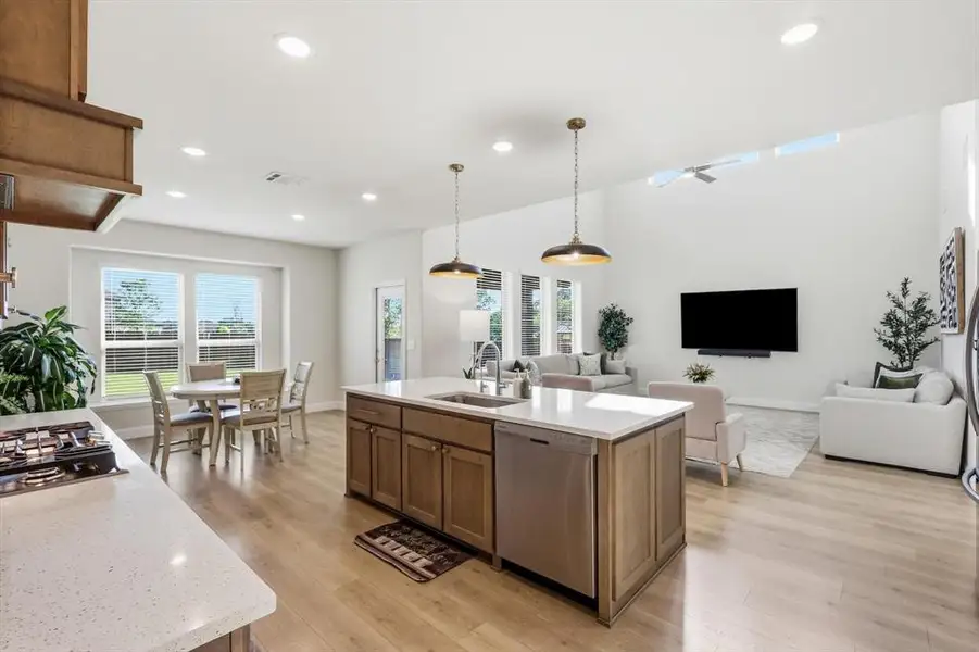 Upgraded Gourmet kitchen with elegant wood cabinets and pendant lights, looking into breakfast room