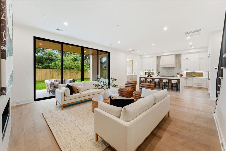 Soaring 11-foot ceilings paired with expansive 10-foot sliding glass doors create an incredibly airy and bright atmosphere in this grand living room providing abundant natural light.