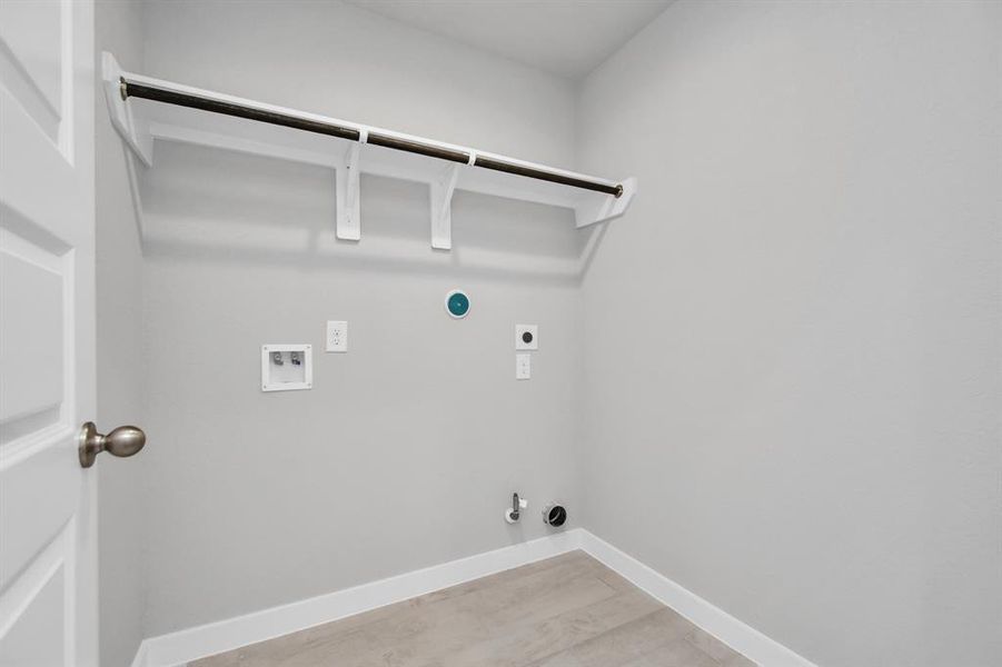 A perfect blend of functionality and comfort. Laundry room, thoughtfully equipped with shelving for effortless organization. Both gas and electric connections available. Sample photo of completed home with similar plan. As built color and selections may vary.