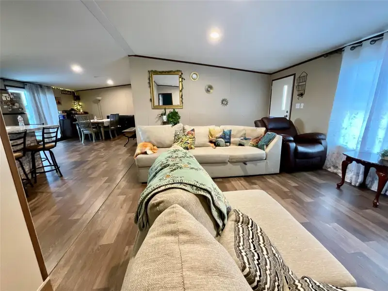 Open-concept living area with wood-finish flooring, recessed lighting, and a neutral color palette