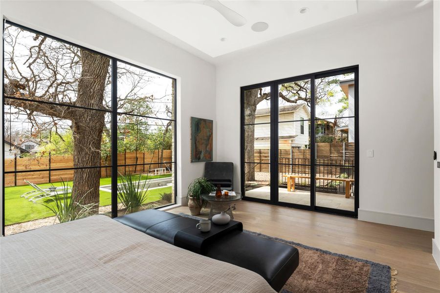 Bedroom featuring access to outside, wood finished floors, and a ceiling fan