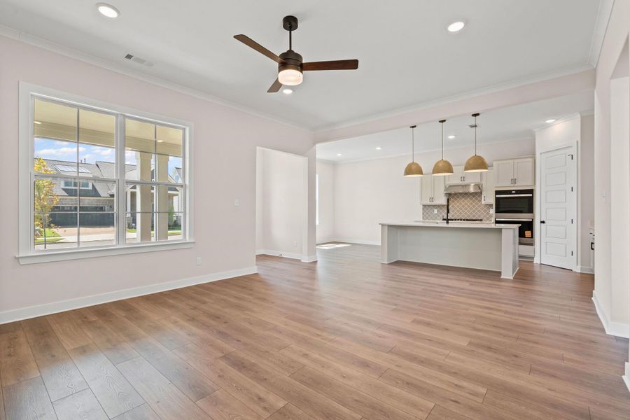 Unfurnished living room with ornamental molding, ceiling fan, light wood-style flooring, and recessed lighting Unfurnished living room with ornamental molding, ceiling fan, light wood-style flooring, and recessed lighting