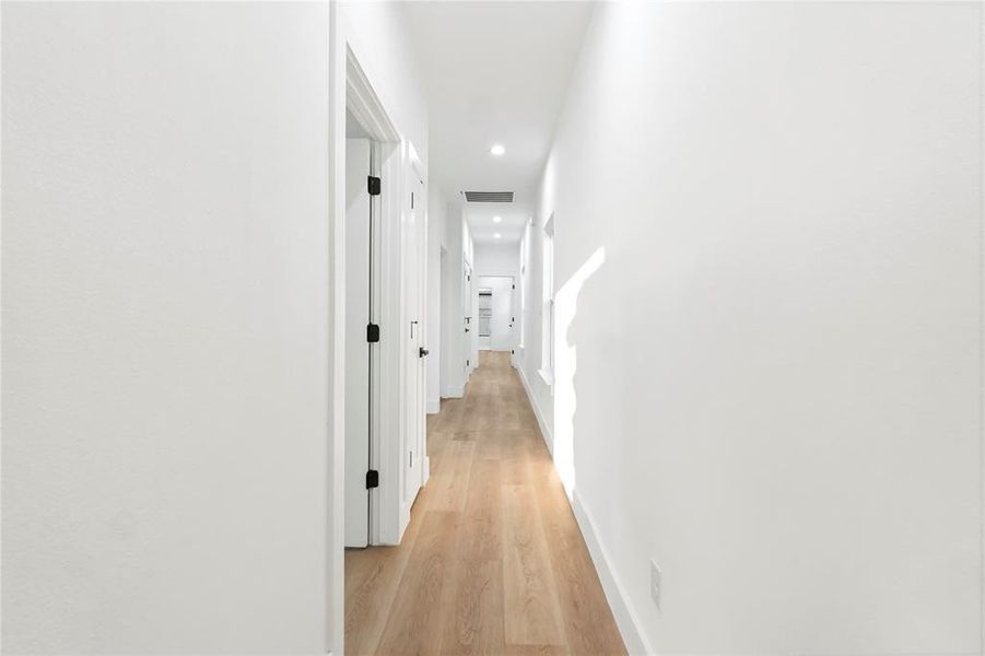 Corridor with light wood-style floors and recessed lighting Corridor with light wood-style floors and recessed lighting
