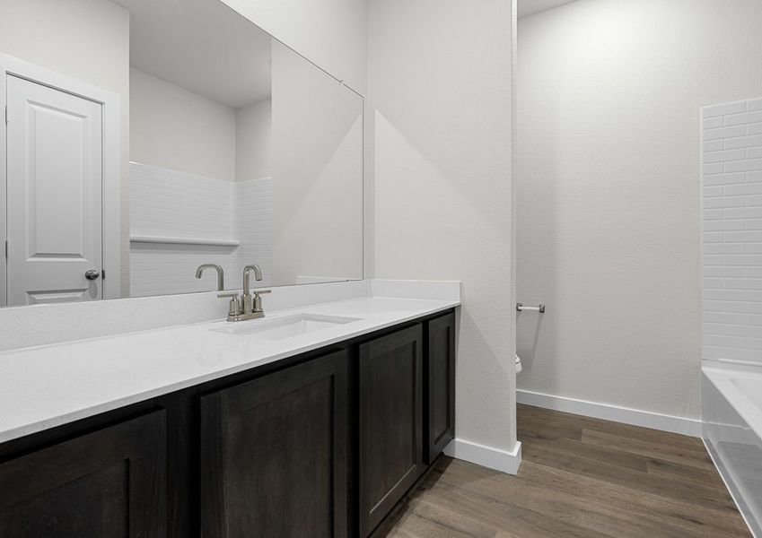 The secondary bathroom has a sprawling vanity space.
