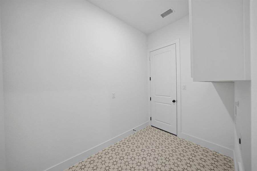 Washroom with baseboards and tile patterned floors