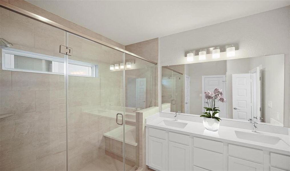 The primary bathroom features double sinks with quartz countertops. The oversized tiled stainless steel framed shower features a sitting bench.