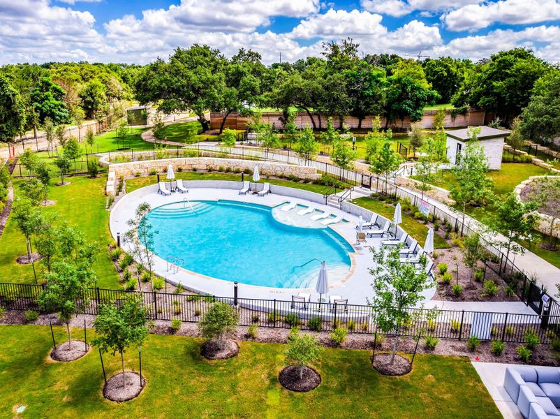 Community pool with a patio area and view of the green space behind Community pool with a patio area and view of the green space behind