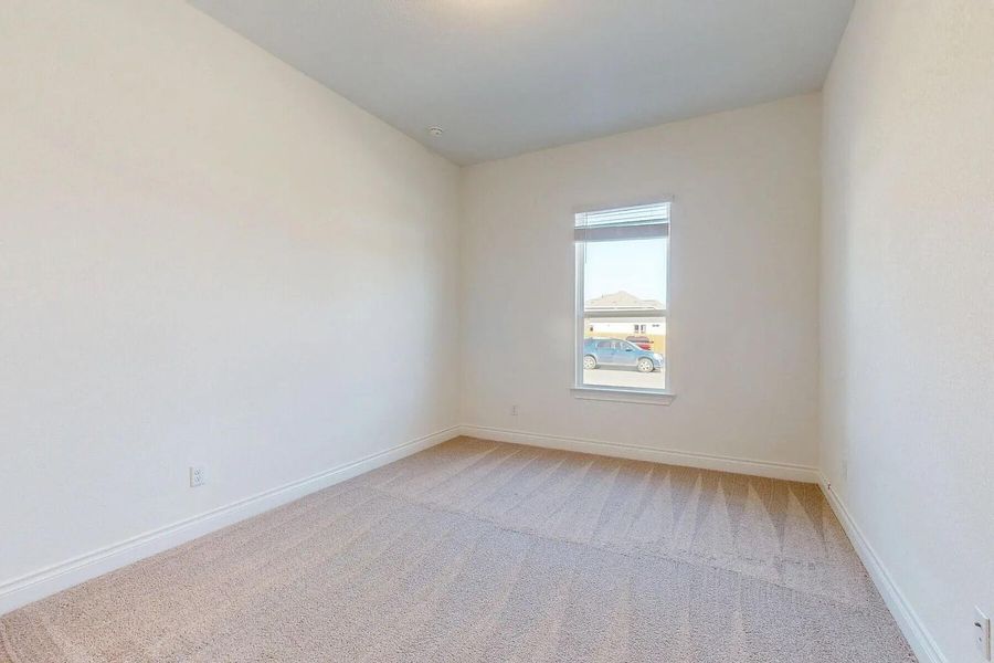 This room features light-colored carpet, a single window with blinds, and neutral-toned walls