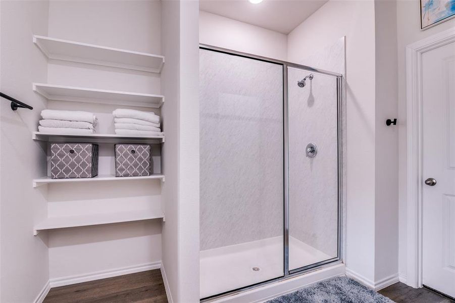 Full bathroom featuring a shower stall and dark wood-style floors Full bathroom featuring a shower stall and dark wood-style floors