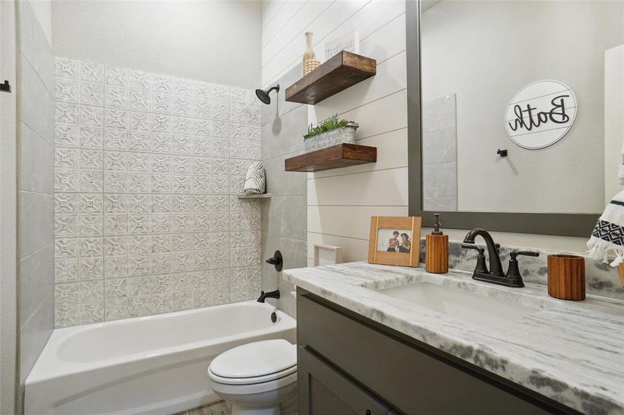 Full bathroom featuring vanity, toilet, and tiled shower / bath