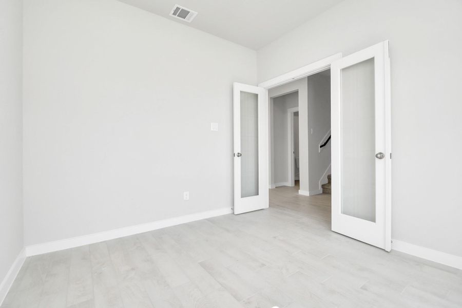 Quietly nestled in front of the home is the sophisticated home office. Featuring plush carpet, custom paint and large windows with privacy blinds. Sample photo of completed home with similar floor plan. Actual colors and selections may vary.