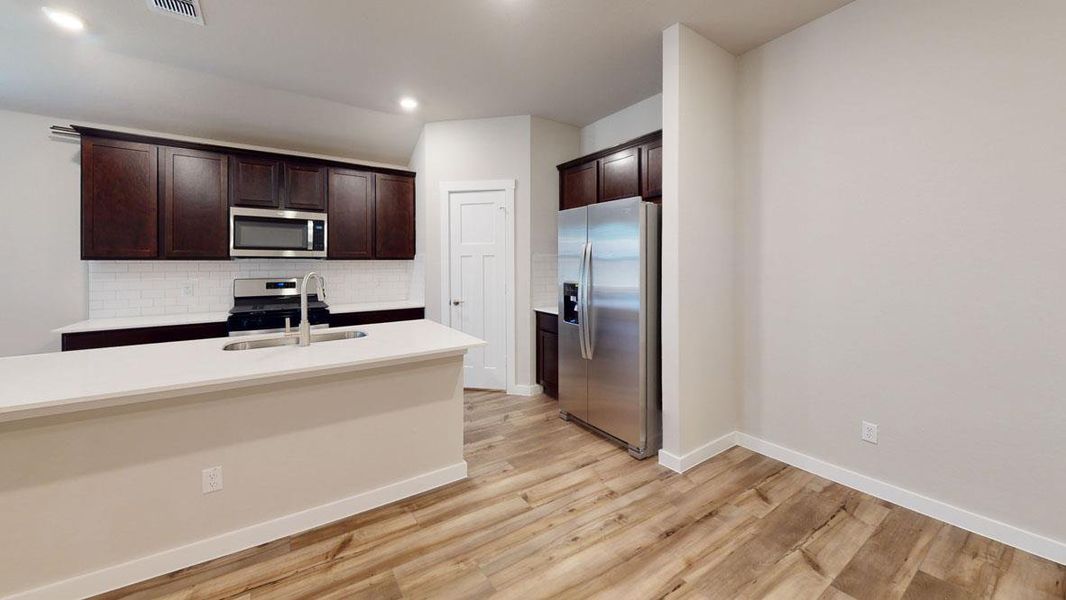 Culinary delights await in this modern kitchen with rich cabinetry and an inviting island. Culinary delights await in this modern kitchen with rich cabinetry and an inviting island.