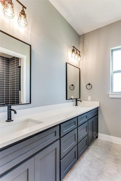 Full bathroom with double vanity and light tile patterned floors Full bathroom with double vanity and light tile patterned floors