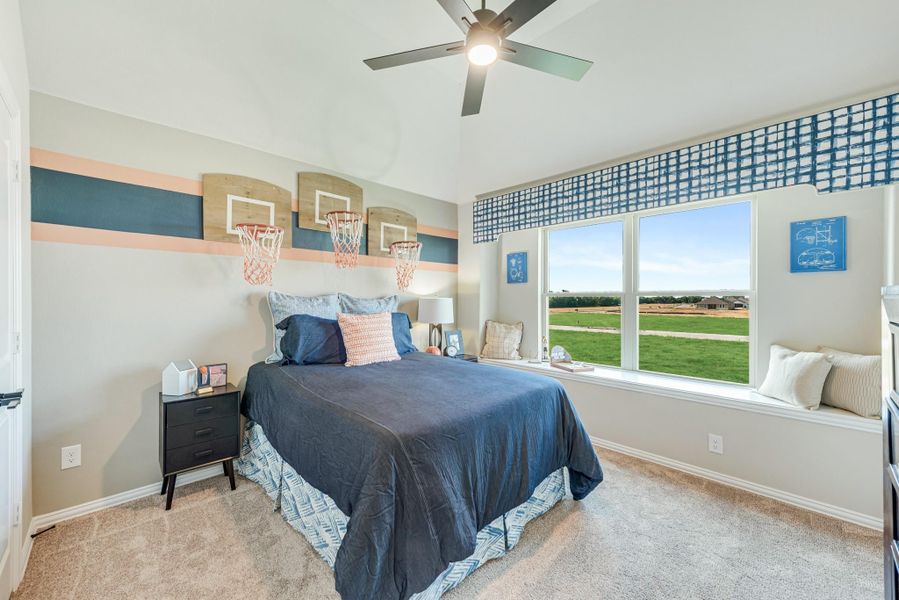 Kids bedroom with basketball hoop wall decor, window seat, ceiling fan, and carpeted floors