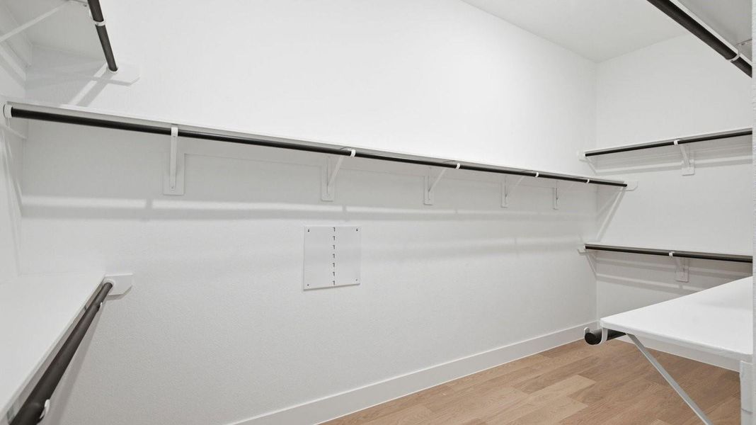 The primary walk-in closet with two rows of shelves and rods for maximum storage opportunities