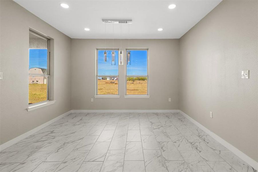 Unfurnished room with light marble finish floors and recessed lighting