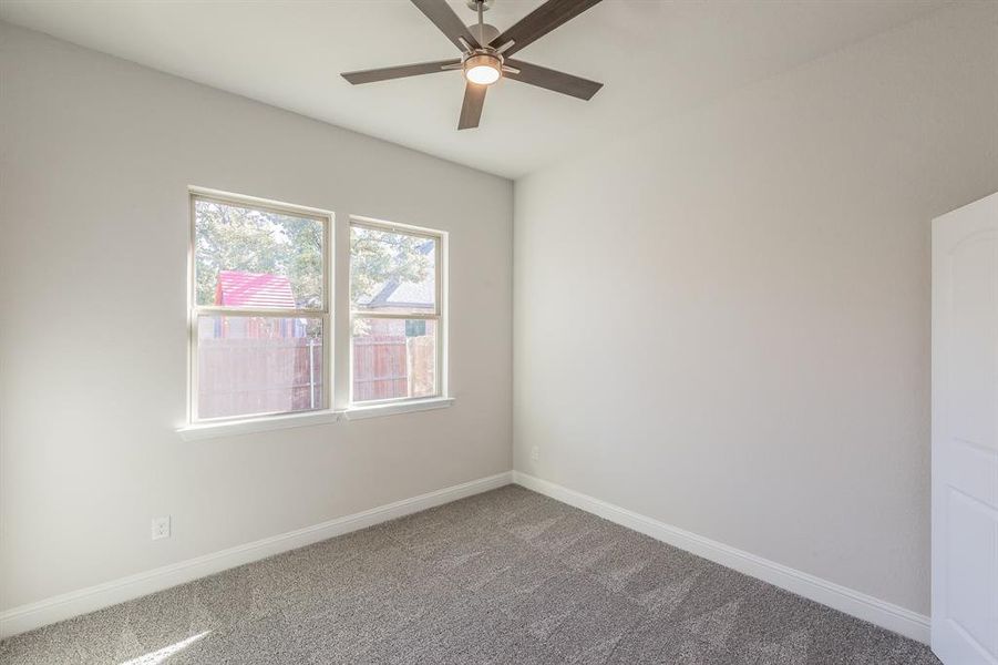 Carpeted spare room with ceiling fan