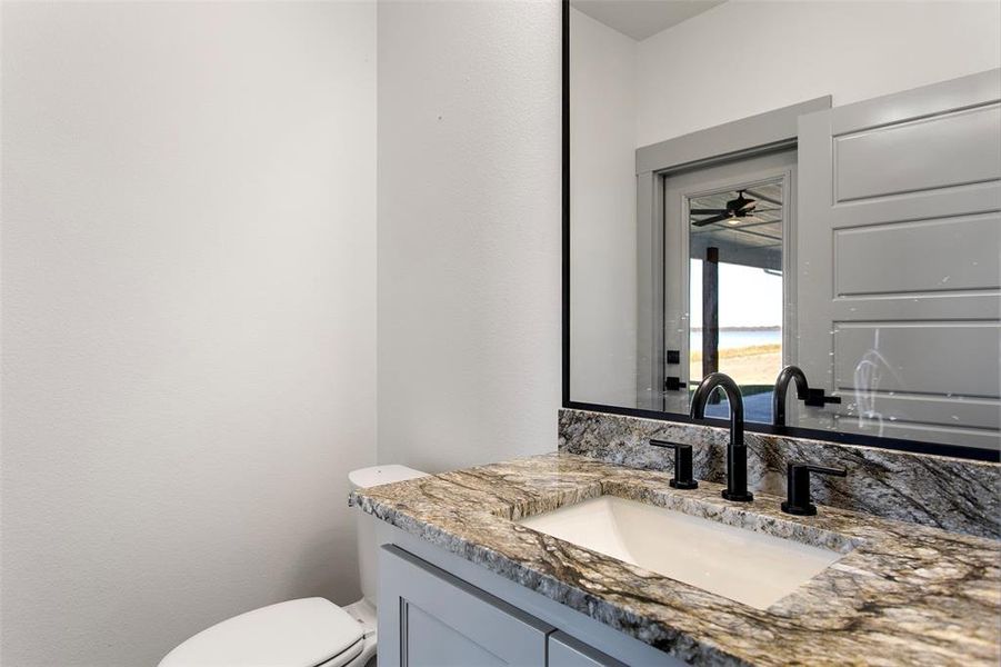 Bathroom featuring vanity, ceiling fan, and toilet