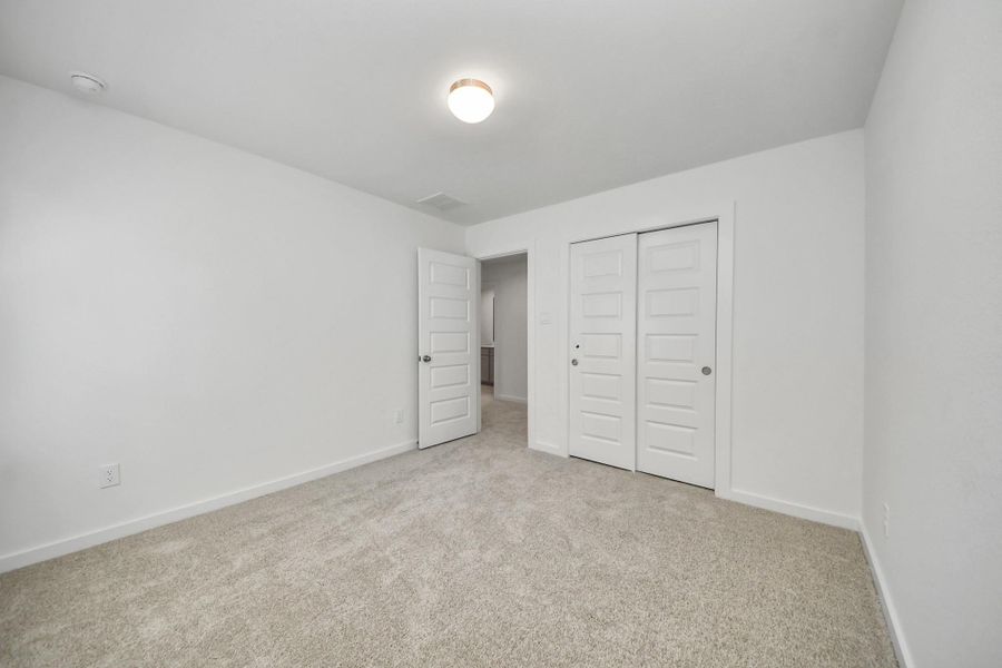 Generously sized secondary bedrooms featuring spacious closets, soft and inviting carpeting underfoot, large windows allowing plenty of natural light, and the added touch of privacy blinds for your personal retreat. Sample photo of completed home with similar floor plan. Actual colors and selections may vary.
