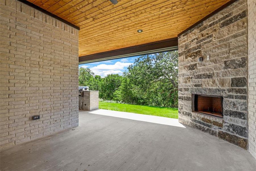 View of patio featuring an outdoor stone fireplace