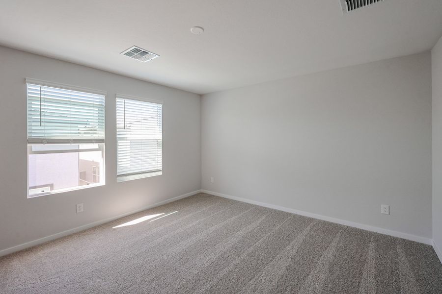 A room with a carpet and windows.