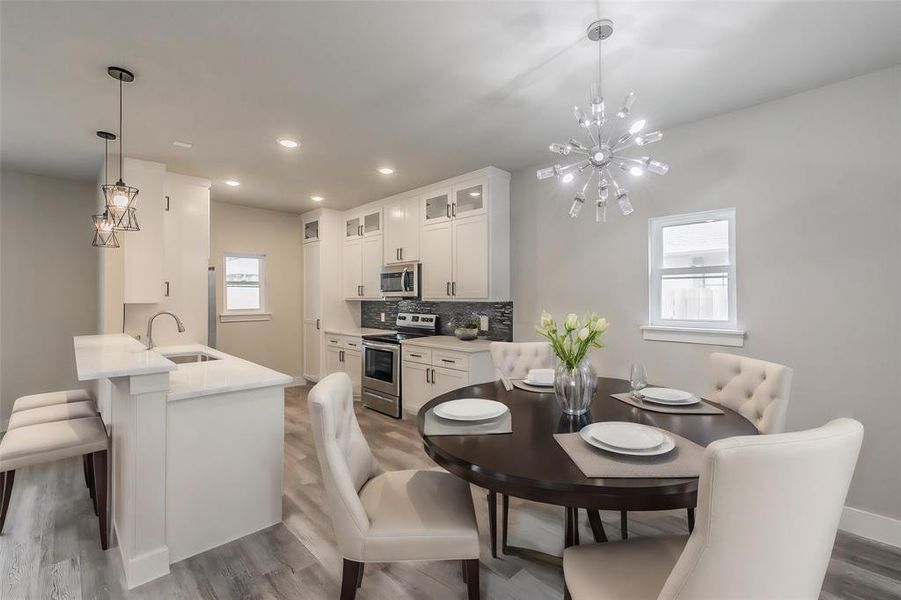 Dining area featuring sink, hardwood / wood-style floors, and a chandelier