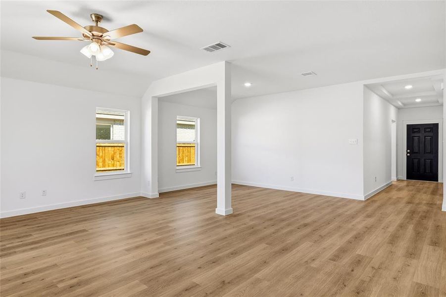 Unfurnished living room featuring vaulted ceiling, light wood finished floors, ceiling fan, and recessed lighting