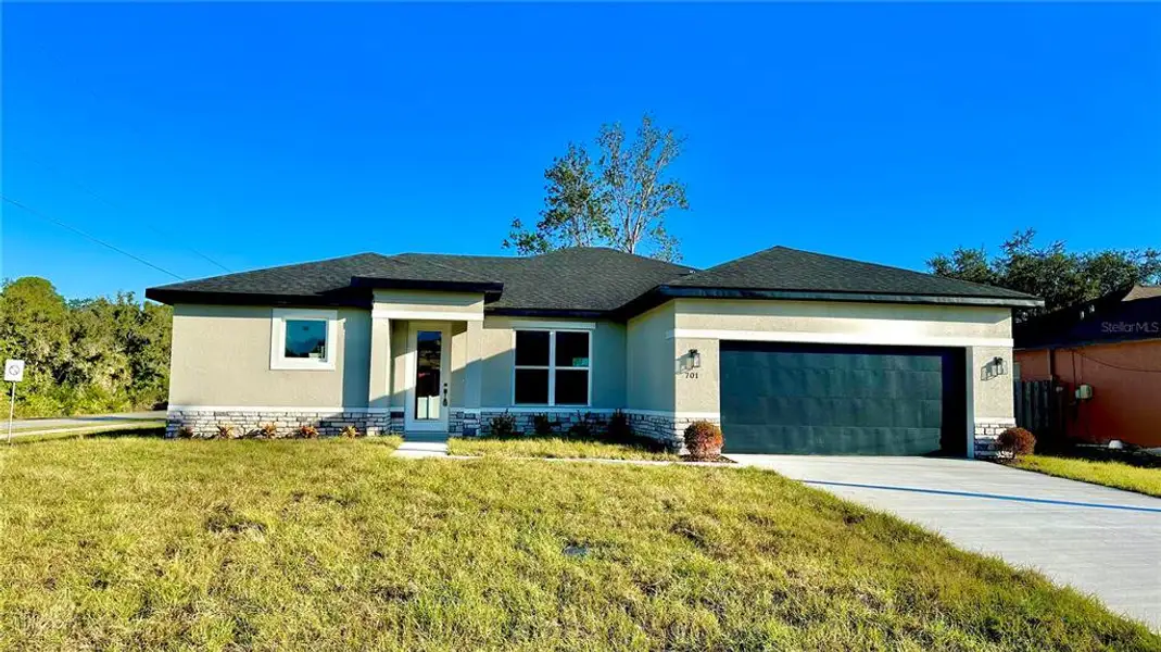 Front exterior of a new home in , Poinciana, FL, highlighting curb appeal (Image 1).