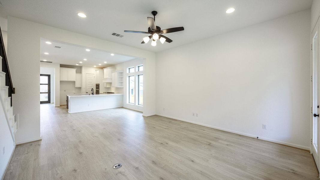 Unfurnished living room featuring light wood-style flooring, plenty of natural light, recessed lighting, and ceiling fan Unfurnished living room featuring light wood-style flooring, plenty of natural light, recessed lighting, and ceiling fan
