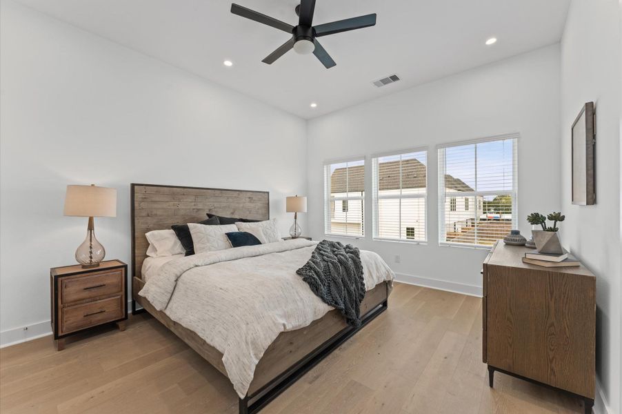 This spacious second-floor primary bedroom exudes modern elegance with its sleek engineered wood flooring that adds warmth and texture underfoot. High ceilings and big windows amplify the sense of openness, allowing natural light to cascade in and highlight the room’s charm. Whether styled with minimalist furnishings or layered with cozy accents, the space offers a serene retreat. This spacious second-floor primary bedroom exudes modern elegance with its sleek engineered wood flooring that adds warmth and texture underfoot. High ceilings and big windows amplify the sense of openness, allowing natural light to cascade in and highlight the room’s charm. Whether styled with minimalist furnishings or layered with cozy accents, the space offers a serene retreat.