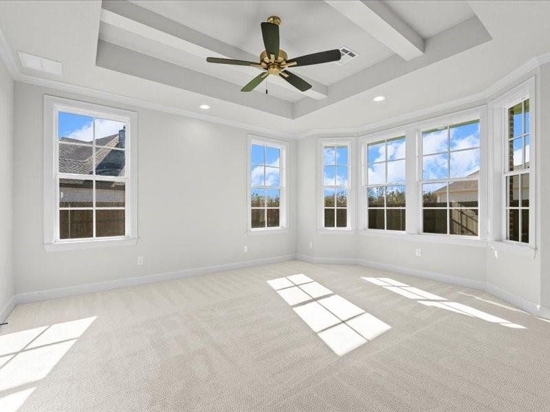 Empty room featuring light colored carpet, a ceiling fan, a raised ceiling, ornamental molding, and recessed lighting Empty room featuring light colored carpet, a ceiling fan, a raised ceiling, ornamental molding, and recessed lighting