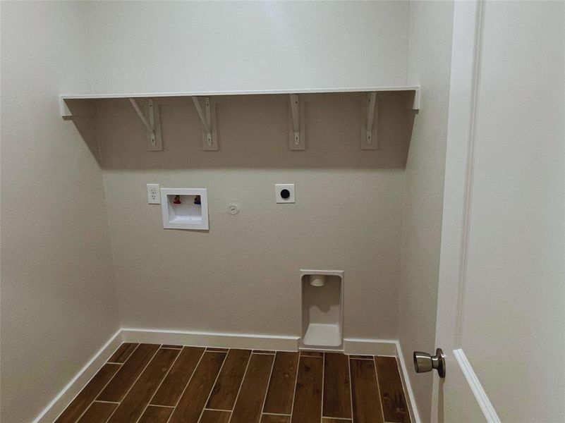 Laundry area with hookup for a washing machine, electric dryer hookup, dark hardwood / wood-style floors, and hookup for a gas dryer