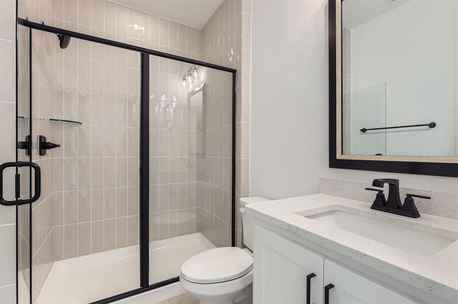 Bathroom featuring walk in shower, vanity, and toilet