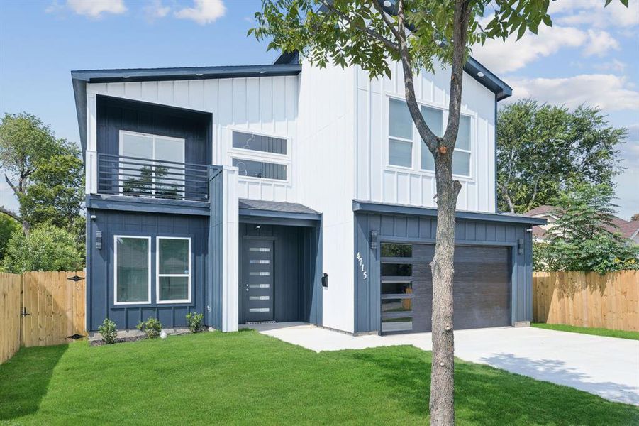 Modern farmhouse featuring board and batten siding, a balcony, a garage, and concrete driveway Modern farmhouse featuring board and batten siding, a balcony, a garage, and concrete driveway
