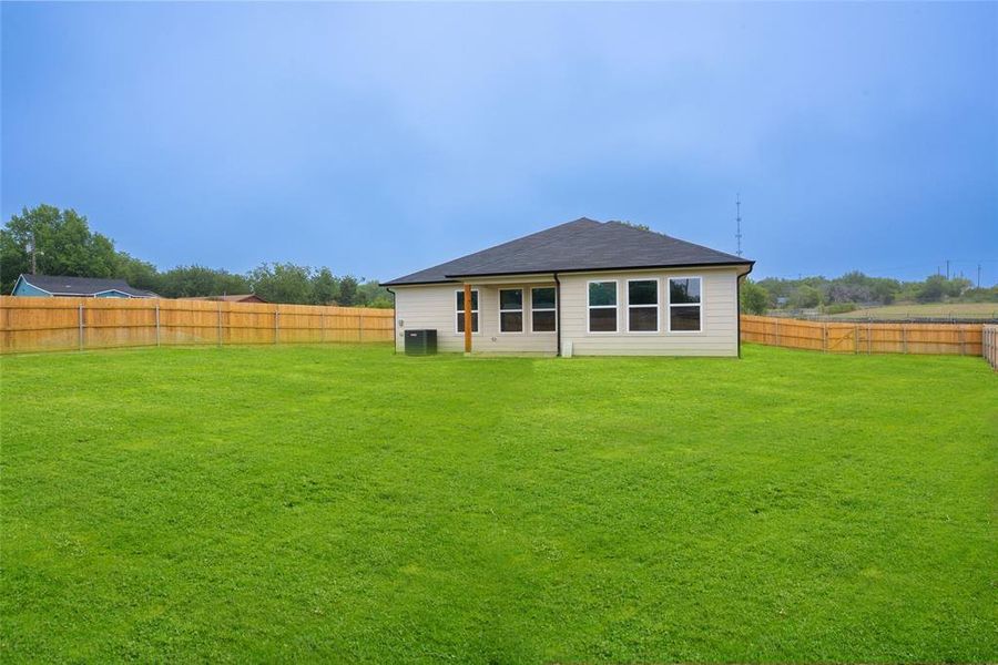 Rear view of house featuring a fenced backyard