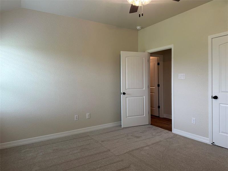 Unfurnished bedroom with carpet flooring and a ceiling fan Unfurnished bedroom with carpet flooring and a ceiling fan