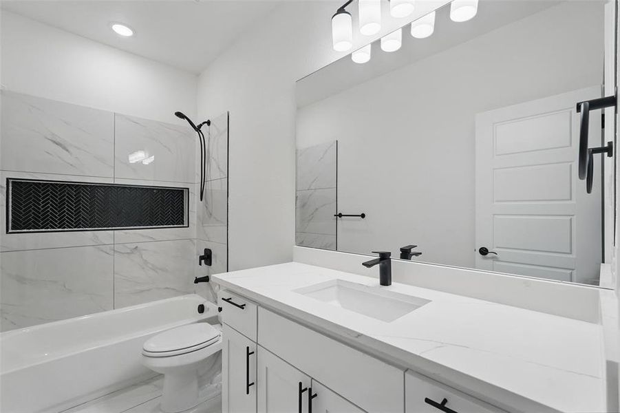 Full bath featuring marble look tile flooring, tub / shower combination, toilet, vanity, and recessed lighting Full bath featuring marble look tile flooring, tub / shower combination, toilet, vanity, and recessed lighting