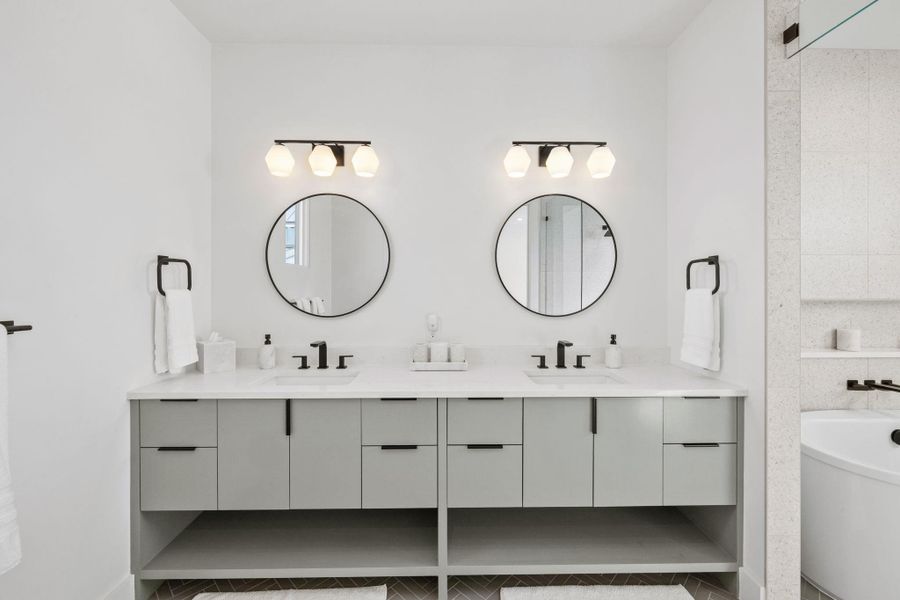 Full bath featuring double vanity, a soaking tub, and light tile patterned floors