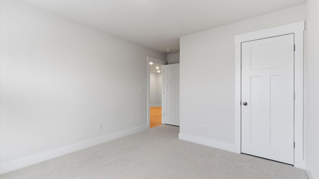 Notable secondary bedroom offering cozy carpeted flooring and a stylish walk-in closet located in Greenville, SC