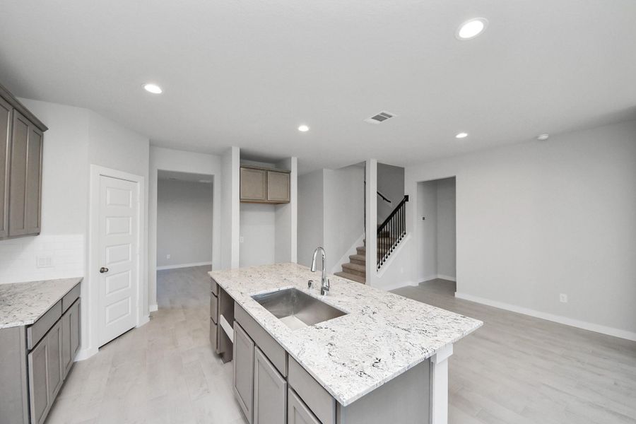 Discover another perspective of this stunning kitchen, generously appointed with an abundance of counter space. Sample photo of completed home with similar floor plan. Actual colors and selections may vary.